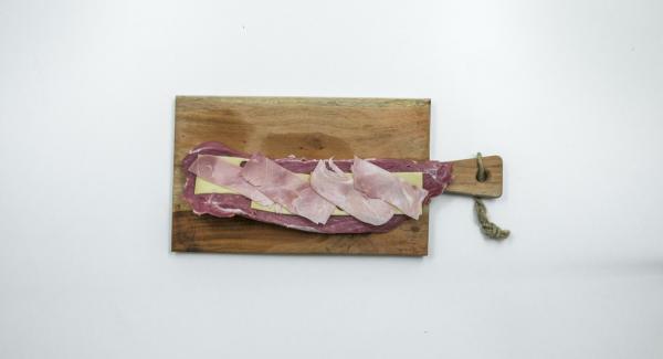 Farcire la lonza con le fette di Emmental, le fette di prosciutto e infine le albicocche tagliate a dadini.