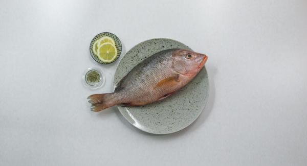 Pepare il pesce all’interno e all’esterno e inserire le fette di limone all’interno.