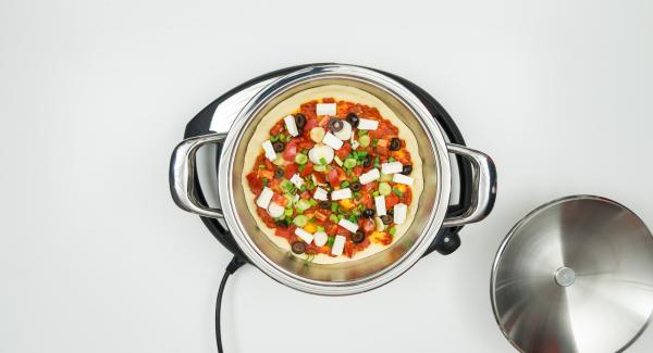 Al suono di Audiotherm, stendere uno strato di pasta all'interno dell'Unità e cospargerlo con il peperoncino. Distribuire sopra le verdure, la feta e le olive.