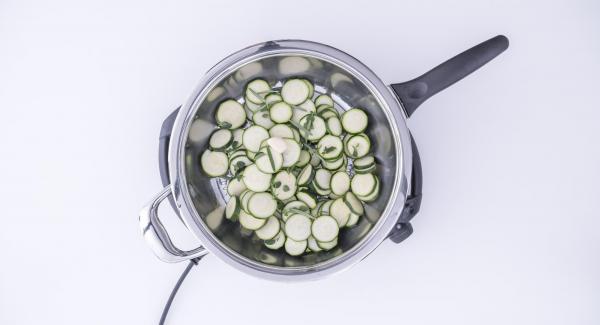 Adagiare le zucchine all'interno della Padella Arcobaleno e aggiungere lo spicchio d'aglio, l'origano e il rosmarino.