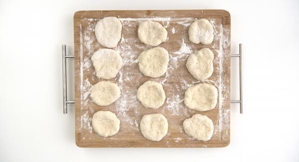 Formare delle palline con la pasta per la pizza. Con le mani distendere le palline lasciando i bordi più spessi rispetto al centro. Bucherellare, con l’ausilio di una forchetta, il centro delle pizzette.