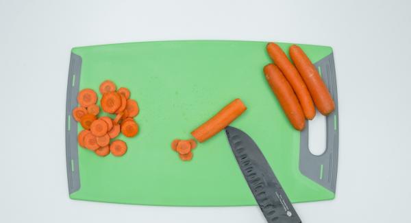 Pelare le carote, tagliarle a rondelle e metterle bagnate d'acqua nell'Unità di cottura 20 cm.