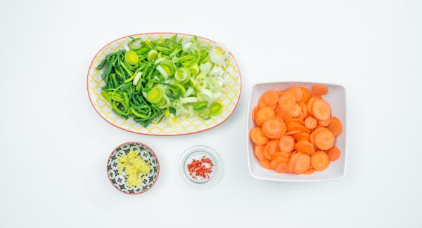 Mondare il porro e tagliarlo ad anelli. Pelare le carote e affettarle molto sottilmente. Pelare lo zenzero e grattugiarlo finemente, privare dei semi il peperoncino e tritarlo finemente.