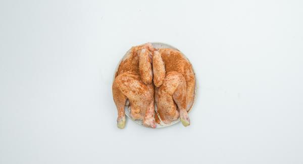 Tagliare a metà il pollo, insaporire con la spezia AMC Intenso e lasciar marinare.