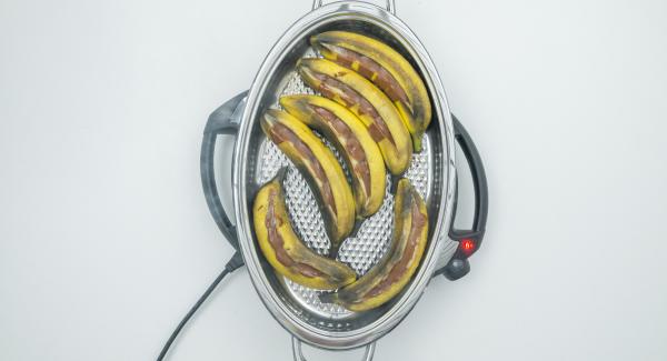 Con l'aiuto di Audiotherm, cuocere fino a raggiungere il “punto di girata” a 90 °C. Togliere il coperchio, estrarre le banane, sbucciarle e tagliarle ai lati.