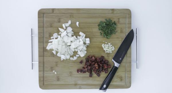 Pelare le patate, tagliarle a cubetti e condirle con l’olio di oliva. Pelare la cipolla e lo spicchio d’aglio e tagliarli a dadini. Tagliare a cubetti il chorizo e tritare le foglie di prezzemolo.