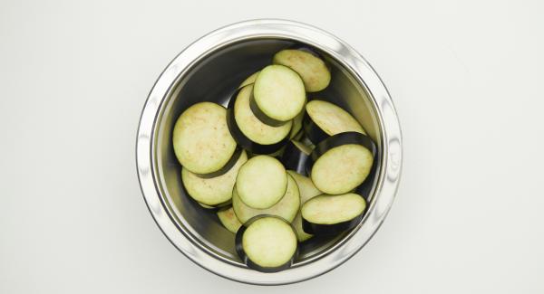 Pulire le melanzane e tagliarle a fette dello spessore di circa 1,5 cm.
Mescolarle in una bacinella 1 cucchiaio di olio e acqua, le spezie, le farine, l'amido di mais e condire con sale.