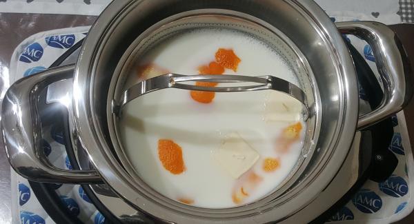 Versare il latte all'interno dell'unità 20 cm 3,0 lt insieme ad un pezzetto di scorza d'arancia ed il burro.
